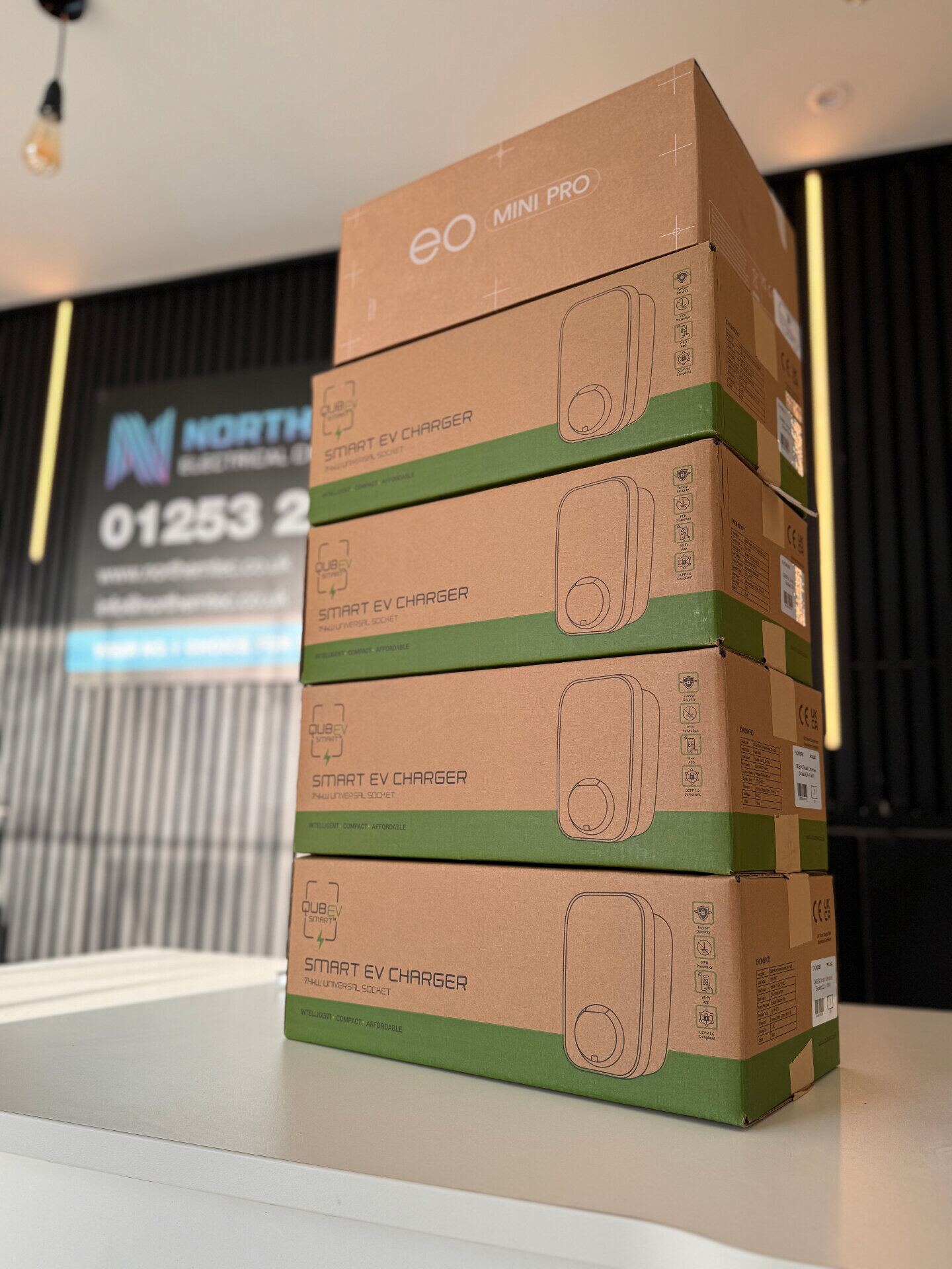 Stack of EO Mini Pro and QubEV smart EV charger units ready for installation at Northern Tec HQ