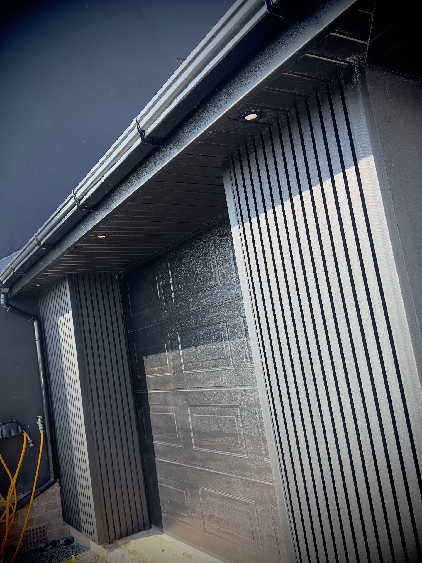 Exterior soffit downlights and black feature cladding fitted on a modern garage conversion