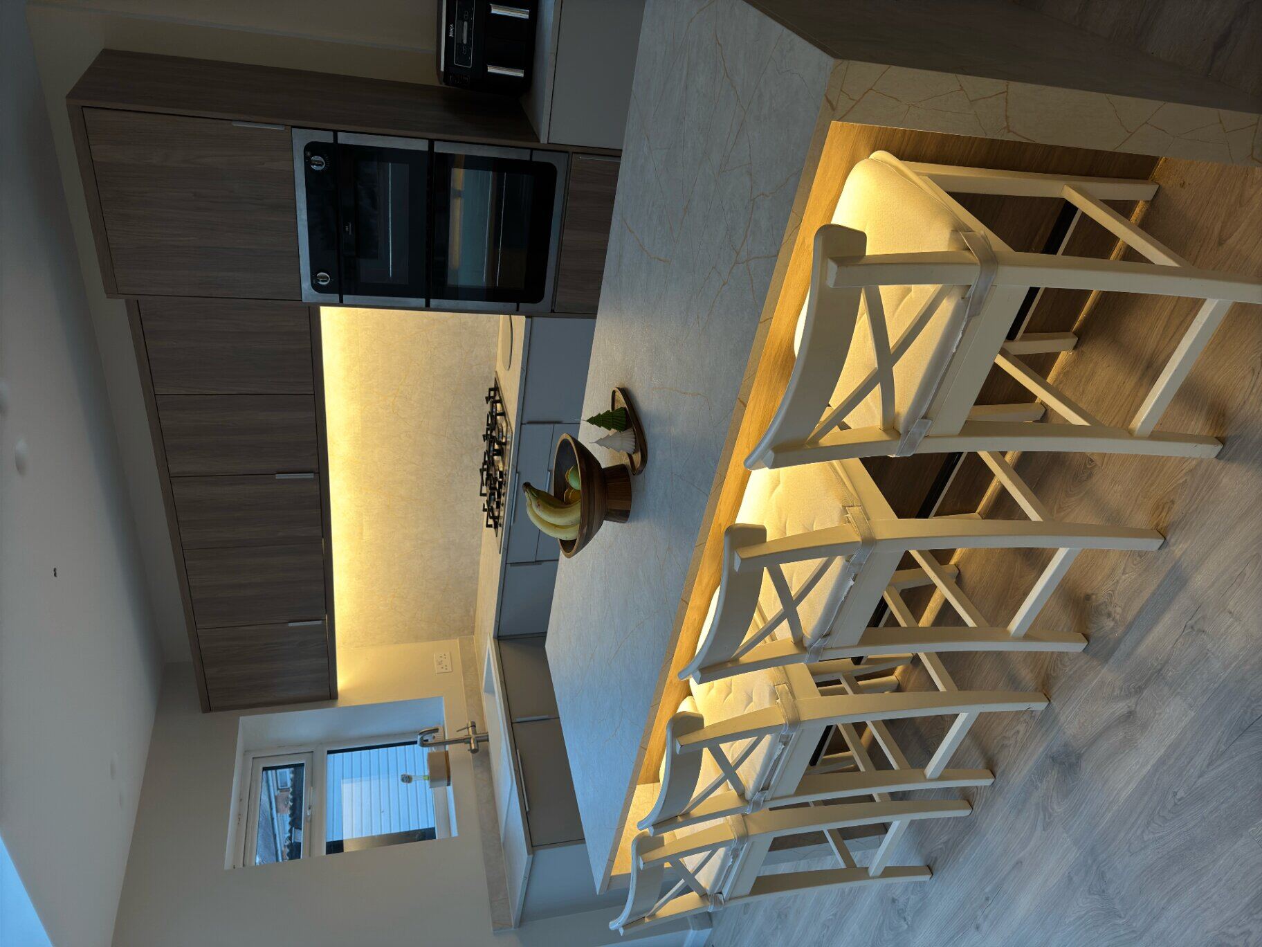 Kitchen island with warm LED underlighting and illuminated splashback installed by Northern Tec