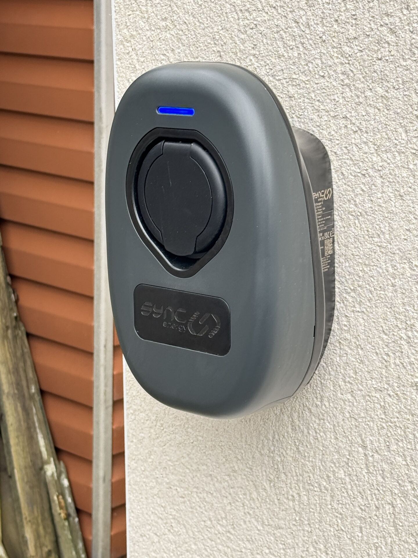 Ohme EV charger fitted beside garden planting